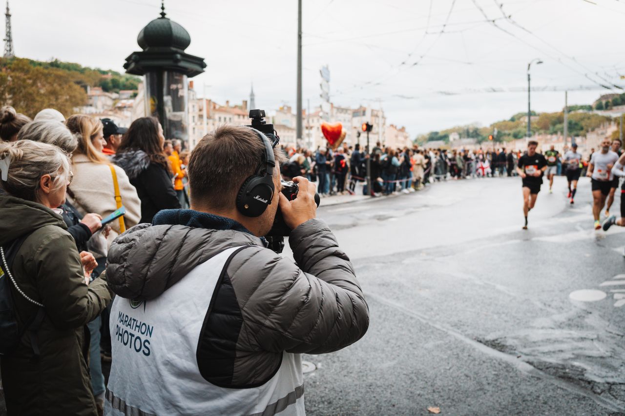 Photographer takes shots at a bustling city marathon event.